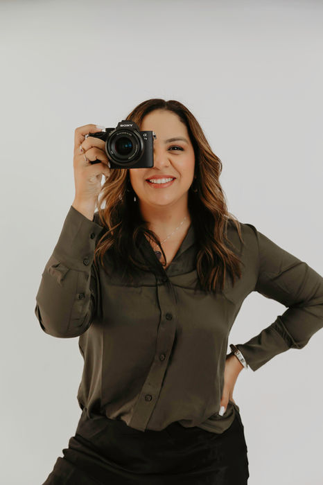 Kathleen Lopes holding her camera in the studio